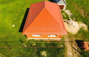 Aerial view of house roof painting with orange metal roof