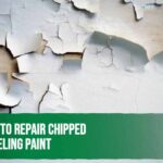 Worker repairing chipped and peeling paint on a wall before repainting.